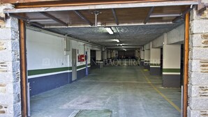 A long, narrow hallway with a concrete floor and metal ceiling, flanked by stone walls. - Azor - Pleta de Nheu (Naut Aran)
