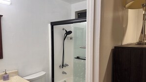 Un baño con ducha, inodoro y lavamanos.