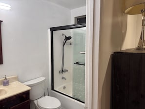 A bathroom with a shower, toilet, and sink.