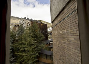 Vista de un edificio con fachada de ladrillo y una ventana que da a un paisaje nevado.