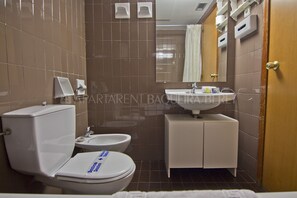 A bathroom with a toilet, sink, and cabinet. - Aran - Edificio Bonaigua (Baqueira)