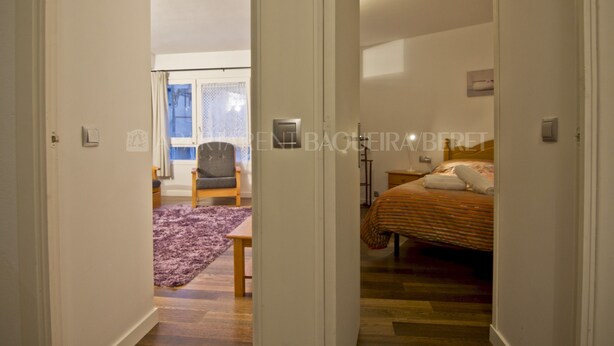 A bedroom with a bed, a chair, and a window. - Urogallo - Edificio Aneto (Baqueira)
