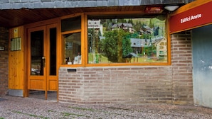 Un bâtiment à la façade en briques, doté de portes en bois et d’une grande fenêtre.