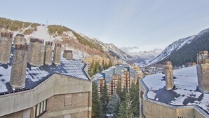 Une station de montagne aux toits et aux bâtiments recouverts de neige, où l’on trouve un mélange d’architecture moderne et traditionnelle.