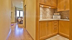 Cocina con armarios de madera, microondas y salpicadero de azulejos.
