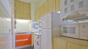 A compact kitchen with a microwave, oven, and sink. - Irissa - Edificio Campalias (Baqueira)