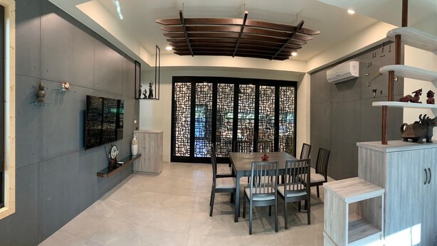A modern dining area with a wooden ceiling, a decorative screen, and a dining table with chairs. - Shui Yifang B&B (Magong)
