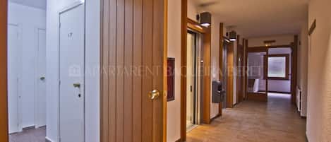 A corridor with wooden doors, a tiled floor, and a visible door labeled "CP".