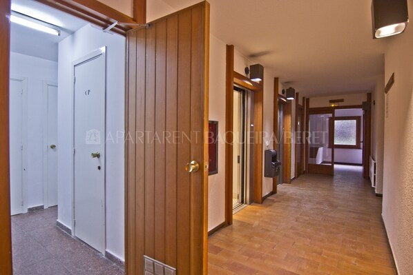 Un pasillo con puertas de madera, suelo de baldosas y una puerta identificada con la etiqueta 'CP'.