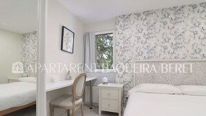 Un dormitorio con dos camas, un escritorio, una silla y una mesita de noche.