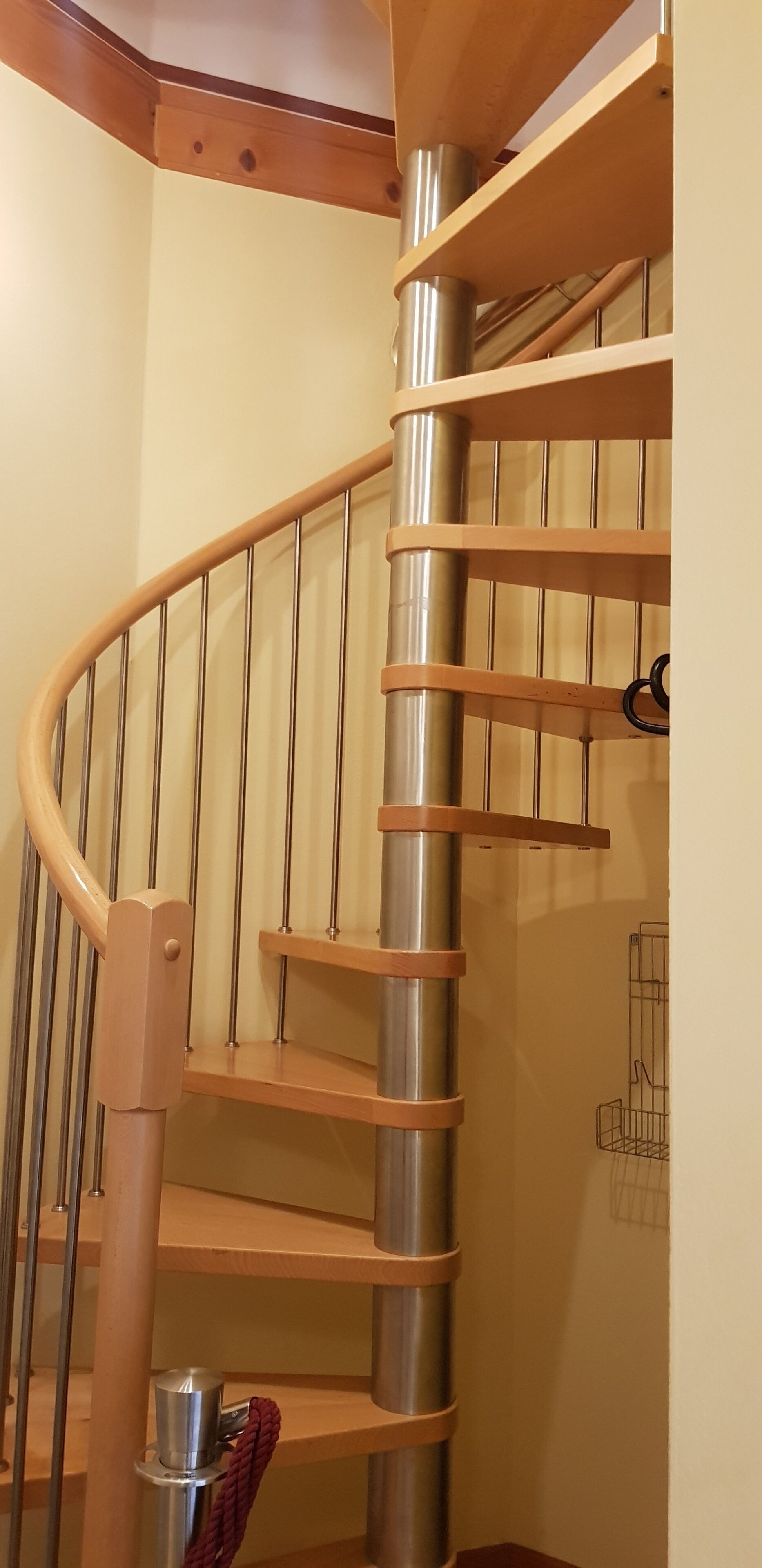 Una escalera de caracol con barandillas de madera y balaustres de metal.
