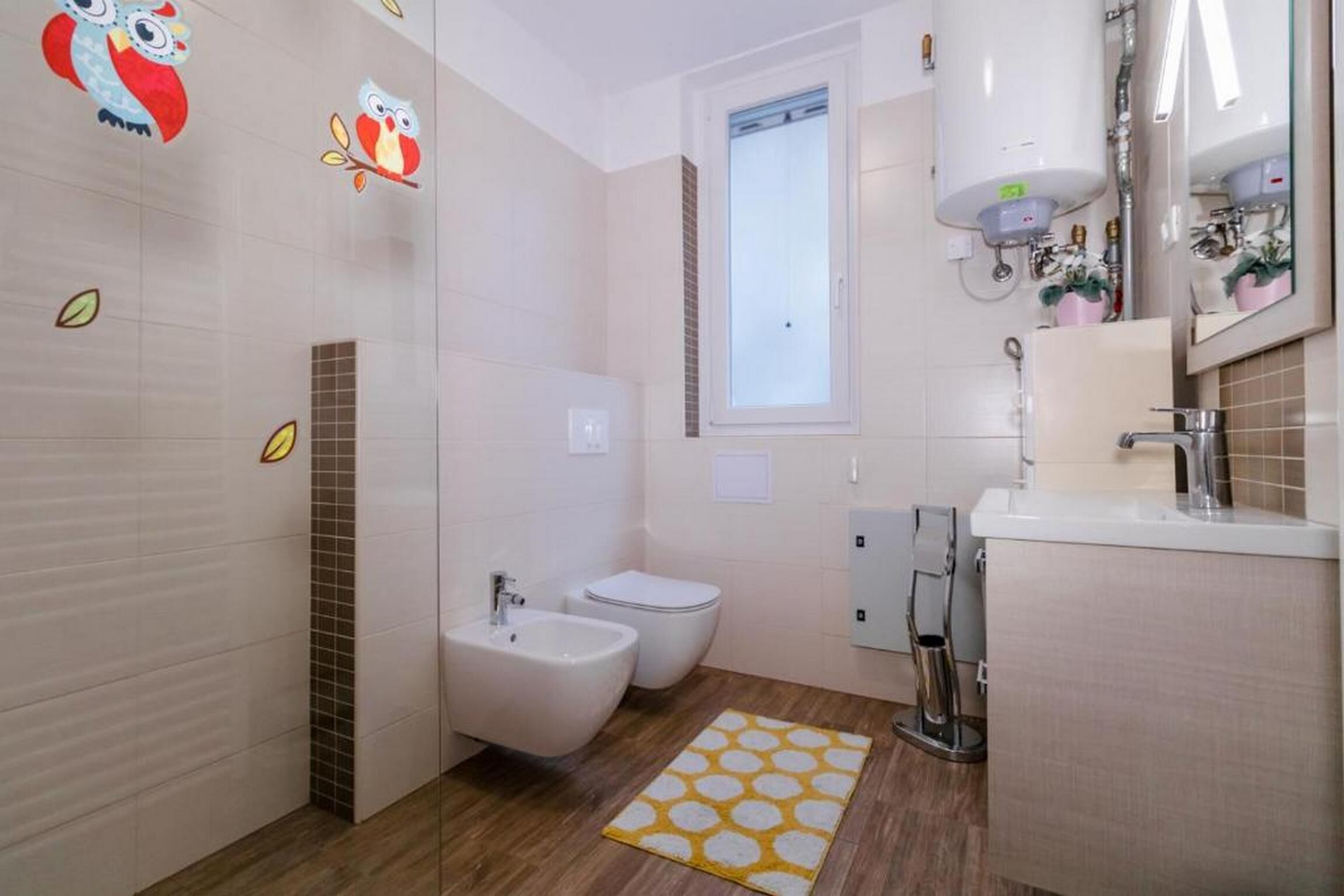 Une salle de bain moderne équipée d’un bidet, de toilettes et d’un lavabo.