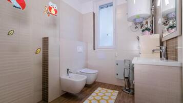 Une salle de bain moderne équipée d’un bidet, de toilettes et d’un lavabo.