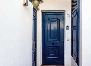 Una puerta azul con cerradura y timbre.
