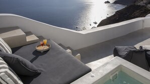 Eine sonnige Terrasse mit Meerblick, ein kleiner Pool und ein Frühstückswagen mit Getränken.