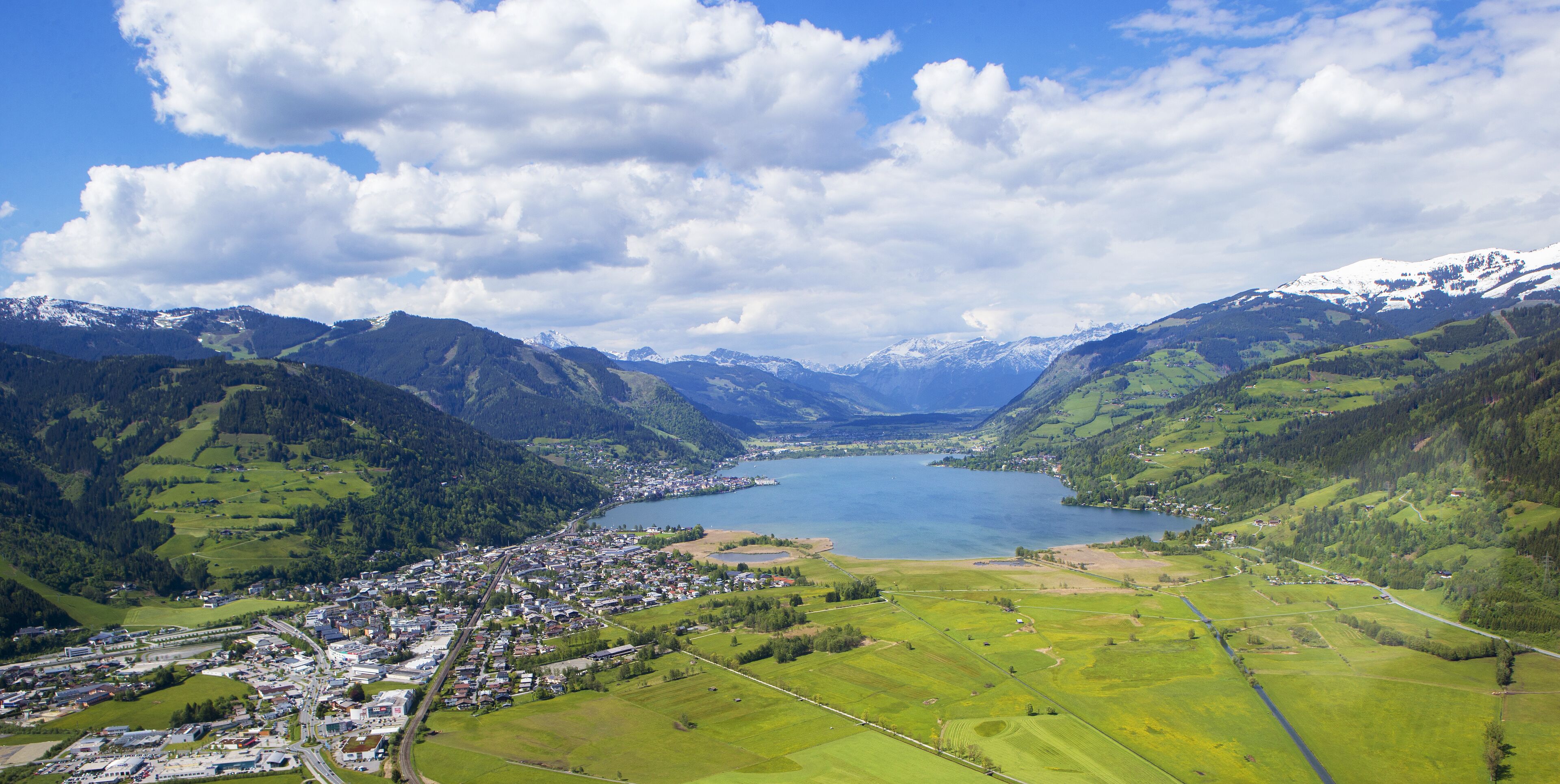 Uma cidade situada entre montanhas, com um lago no centro.