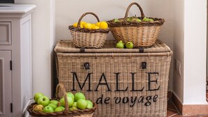 A kitchen with wicker baskets containing fruits, a shelf with hats, and a sign reading "MALL DE VOYAGE". - Farmhouse in Maremma a few steps from the sea (Albinia)