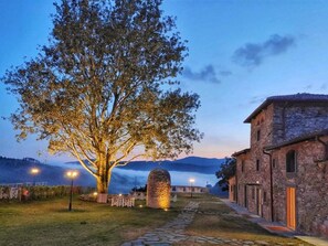A stone building with a traditional architectural style, a large tree in front, and a stone pathway leading to the building. - Agri Resort & Spa Le Colline del Paradiso (Vaglia)