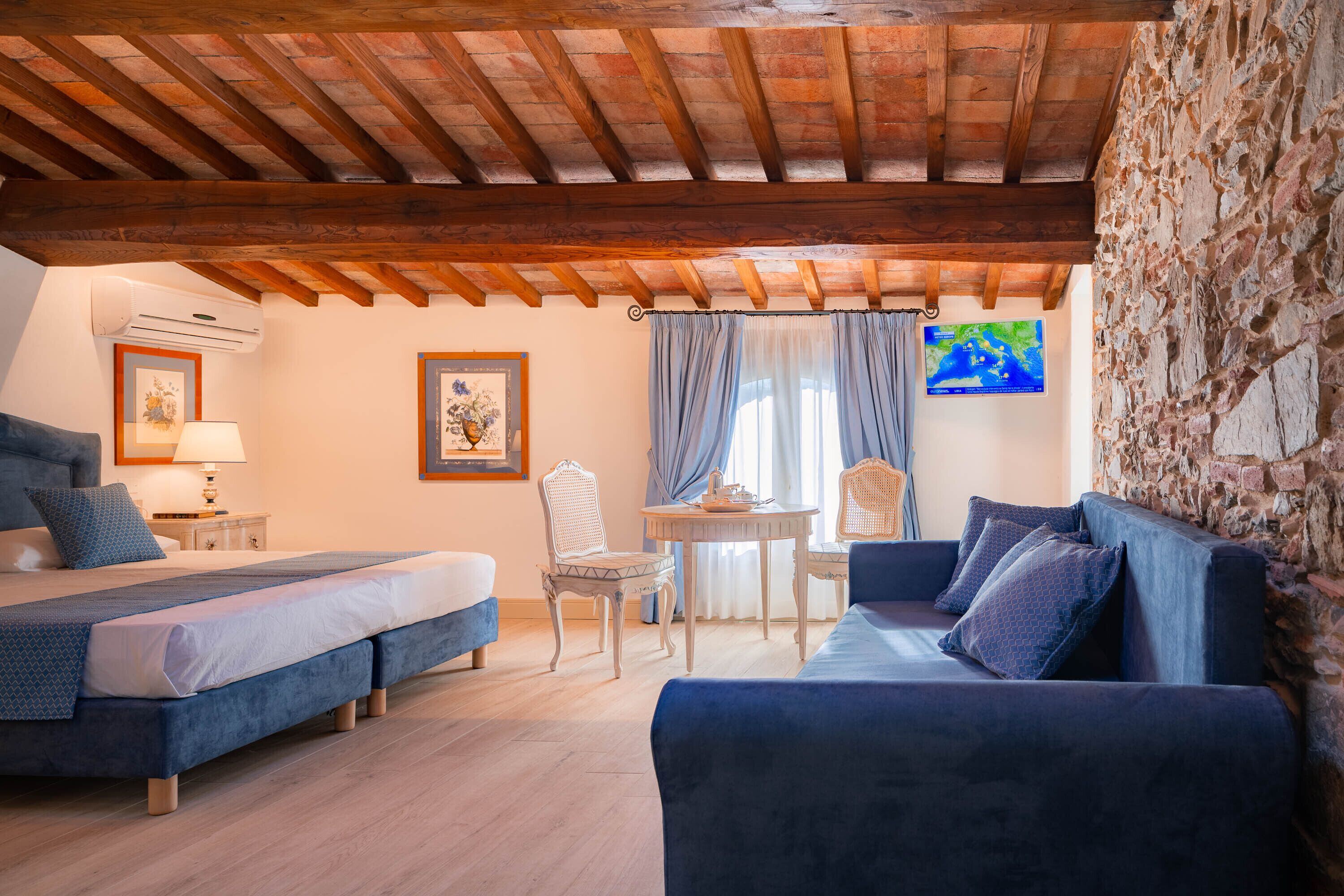 Un dormitorio con una cama, dos sofás, una mesa y sillas.