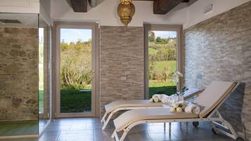 Relax in a serene space with two reclining chairs and a stunning garden view.
