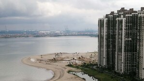 A high-rise building adjacent to a beach with a curved shoreline and palm trees. - Forest City Ataraxia Park 4  by Wastone (Gelang Patah)