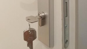 A door with a keyhole, a key, and a door handle. - ABAI Hostel (Vienna)