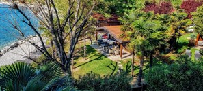 Une propriété située sur la côte, dotée d’un patio, d’un petit bâtiment et d’une végétation luxuriante.
