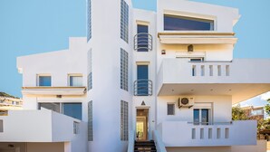 A modern multi-story building with a central staircase, balconies, and large windows. - Aeonian Mansion (Zakynthos)