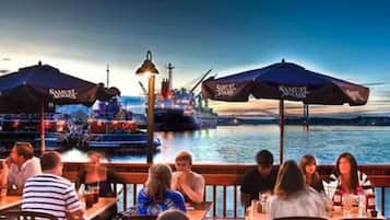 Dine by the water with a view of the ship.