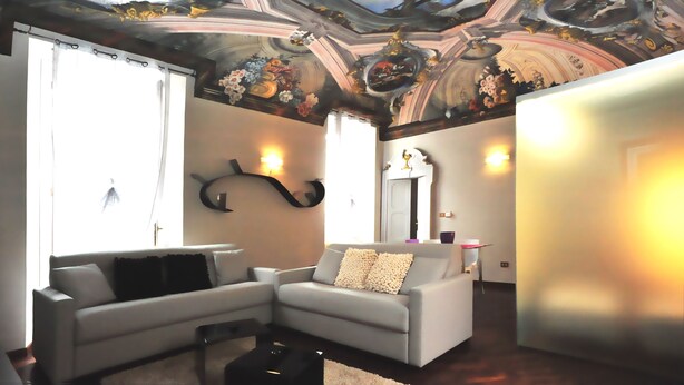 Una sala de estar con un sofá moderno, una mesita de centro y un techo decorativo.