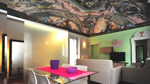 Una sala de estar con una mesa de vidrio, sillas blancas y un sofá.