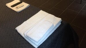 Un baño moderno con una bañera independiente, una pequeña planta en maceta y una silla.
