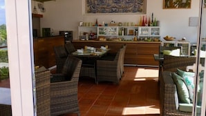 A dining area with wicker furniture, a tiled floor, and a ceiling fan. - Vida-Vi, Country House and B&B (Caldas da Rainha)