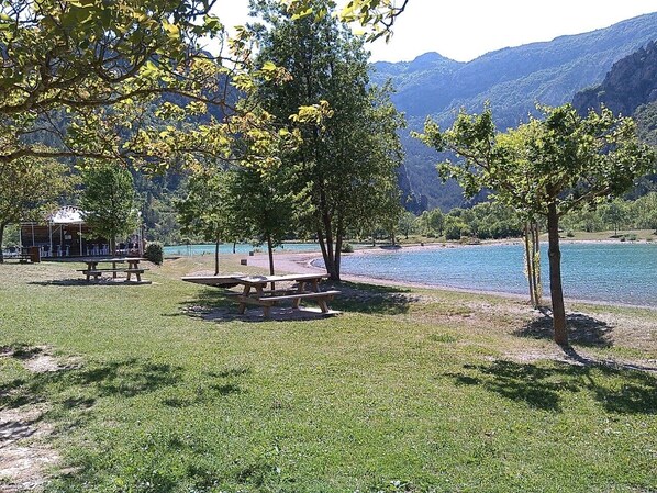 Un parc au bord du lac, équipé de tables de pique-nique et d’un kiosque.