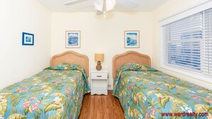 A bedroom with two beds, a ceiling fan, and a window with blinds. - Periwinkle - Oceanfront 3 BR, 2.5 BA home in Surf City!  Dog Friendly! (Surf City)