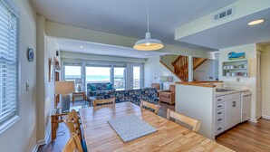 A spacious living area with a dining table, sofa, and a view of the ocean. - Periwinkle - Oceanfront 3 BR, 2.5 BA home in Surf City!  Dog Friendly! (Surf City)