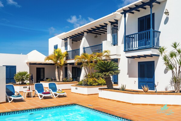Un espace aménagé au bord de la piscine, avec des chaises longues et une piscine.