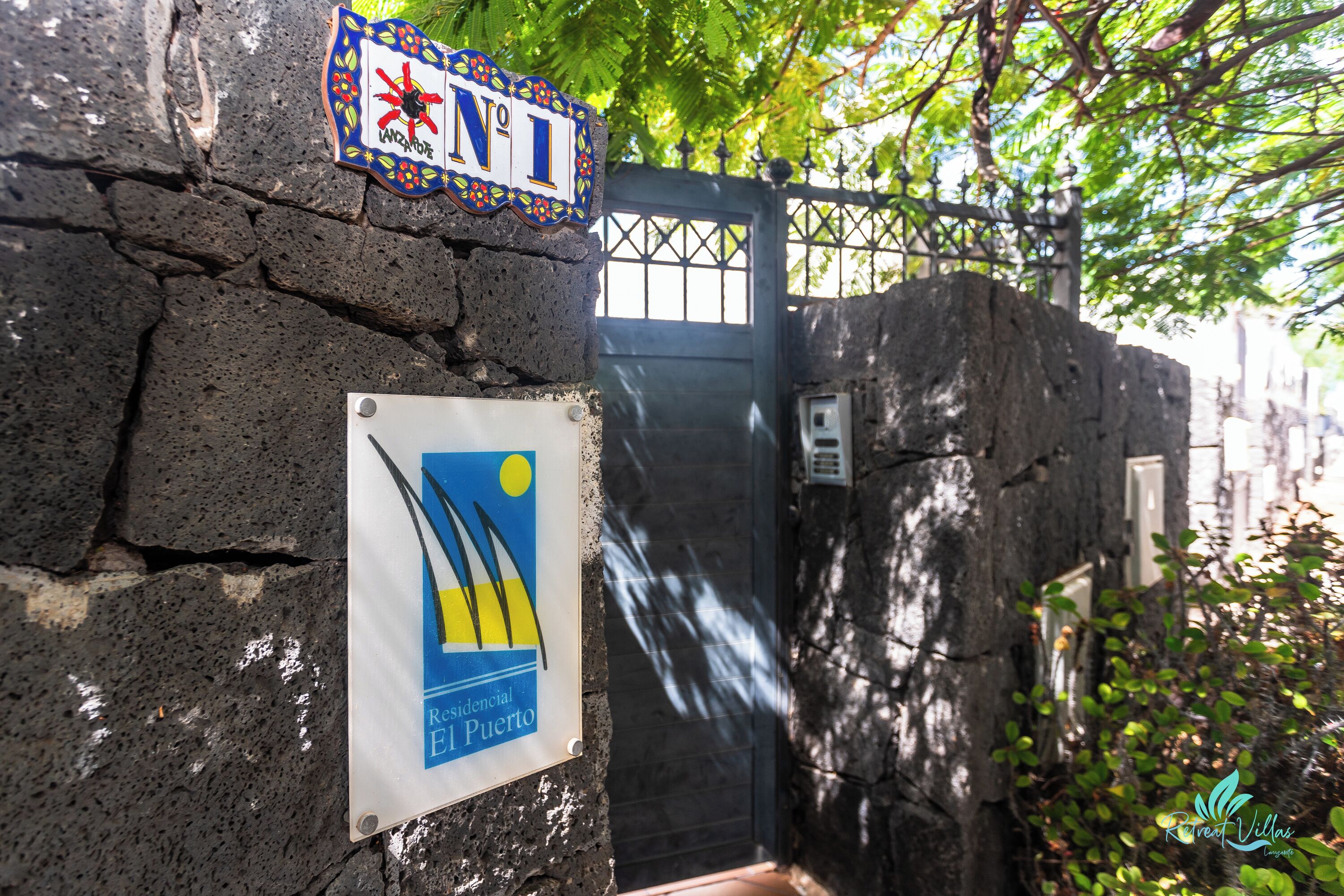 Un mur de pierre sur lequel est apposée une plaque indiquant qu’il s’agit d’une zone résidentielle à El Puerto.