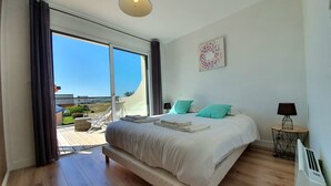 Un dormitorio con una cama grande, vistas al exterior e iluminación en el techo.