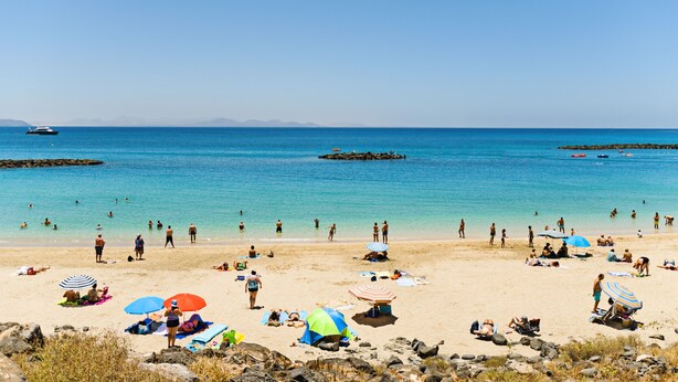 A beach with people sunbathing and swimming, umbrellas, and boats in the water. - Apartment 4 Small block of 6 apartments, a stones through from Marina Rubicon (Yaiza)