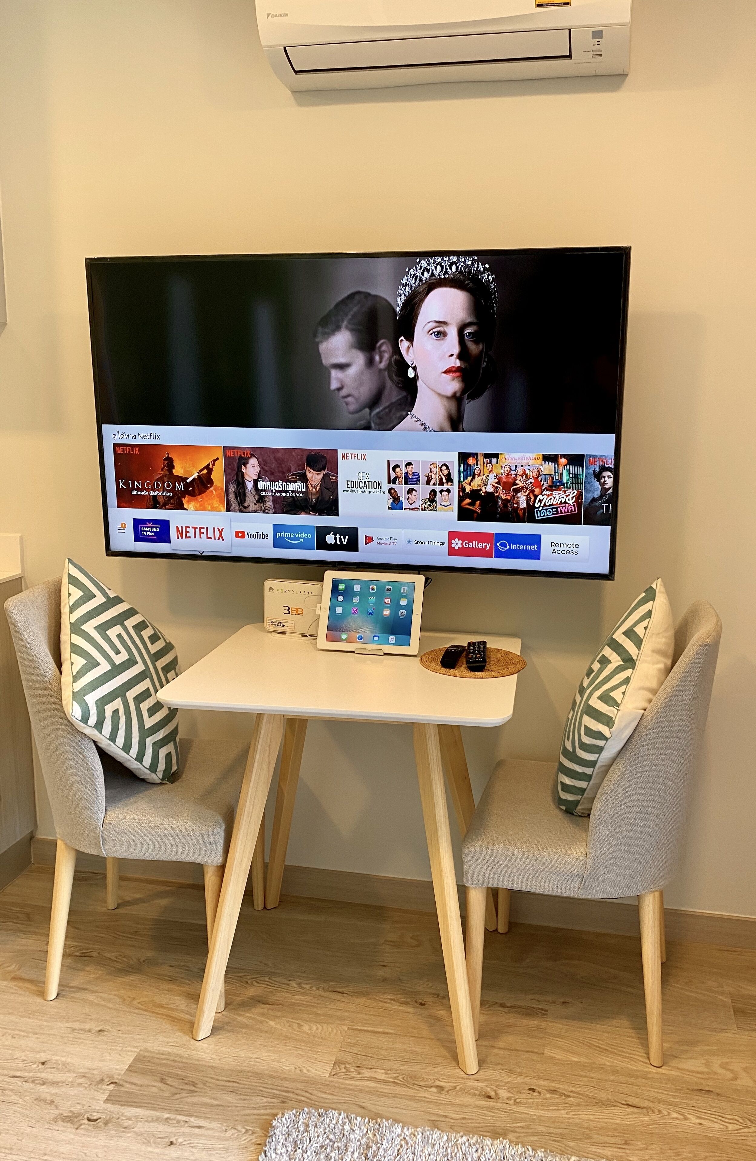 A flat-screen TV mounted on a wall displaying various streaming services.