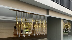 A modern outdoor area with a series of hanging light fixtures and a tiled floor.