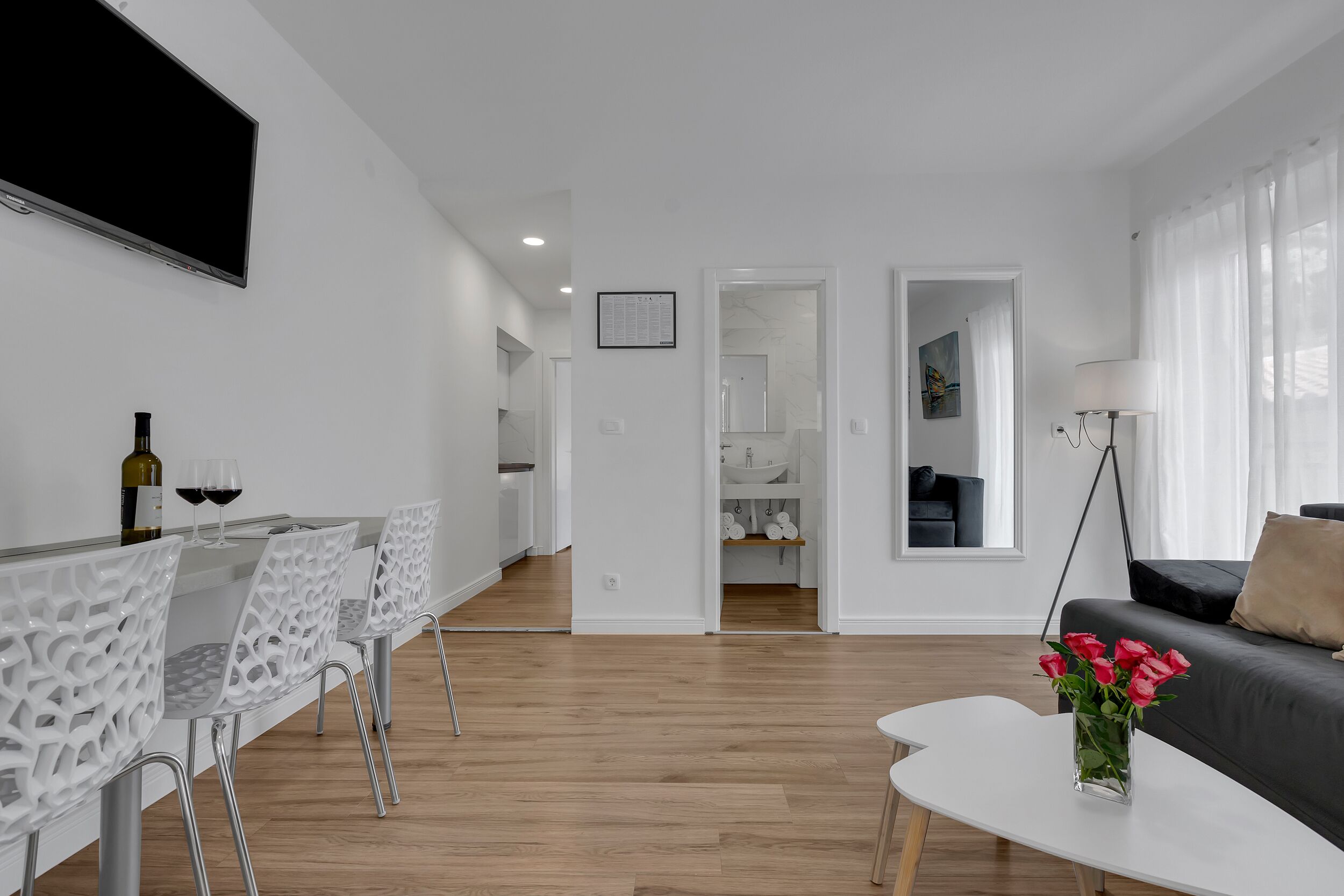 Un salon moderne comprenant un coin repas, un canapé et un vase de fleurs.