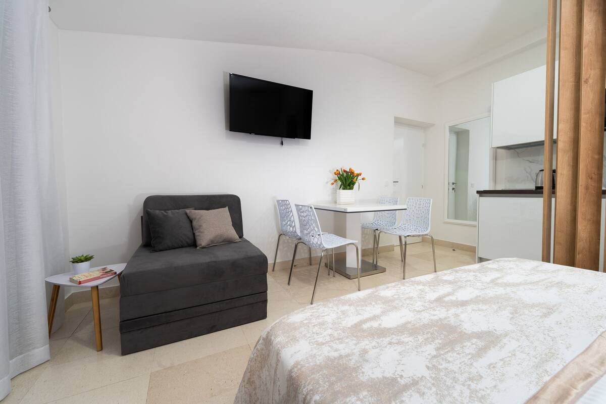 Une chambre d’hôtel moderne équipée d’un lit, d’un canap é, d’un bureau et d’une télévision.