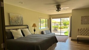 A bedroom with a bed, a ceiling fan, a window, and a chair. - Incredibly spacious Gathering place, Private Pickleball Court, Sleeps 14, (Scottsdale)