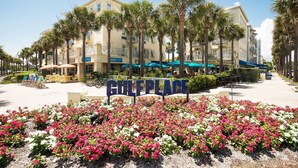 A hotel named "GULF PLACE" with a sign in front, surrounded by palm trees and flower beds. - Beach Views on 30A! (Santa Rosa Beach)
