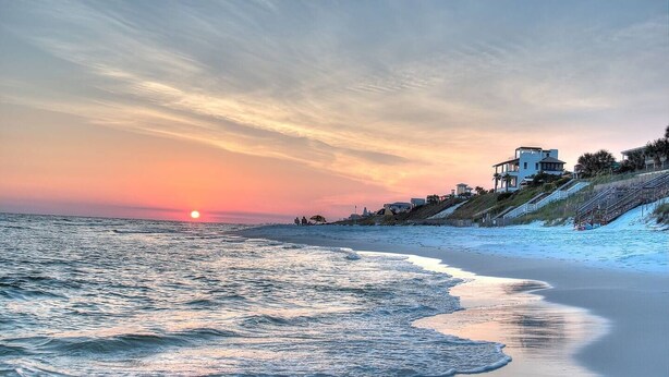 A beach with a sunset, ocean waves, and buildings along the shore. - Beach Views on 30A! (Santa Rosa Beach)