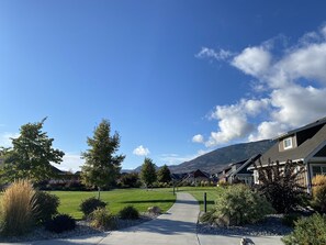 A suburban neighborhood with houses, a clear sky, and a mountain in the background.