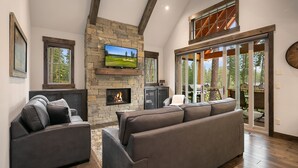 A modern living room with a stone fireplace, a large flat-screen TV, and a cozy seating area. - Big Home with LOW RATES! In the Heart of Suncadia Resort | Hot Tub | WiFi (Cle Elum)