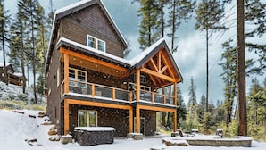 A wooden cabin with a balcony, surrounded by snow-covered ground and trees. - Big Home with LOW RATES! In the Heart of Suncadia Resort | Hot Tub | WiFi (Cle Elum)